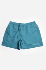 Short de baño liso color azul con cintura elástica ajustable con cordón, bolsillos laterales, tela ligera de secado rápido, suspensor interno y logo estampado.
