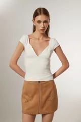 Top blanco de manga corta, ajustado al cuerpo y con escote profundo en V.