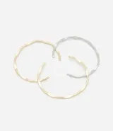 Set de tres brazaletes rígidos de metal con efecto arrugado, uno dorado, uno plateado y uno bicolor.