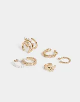 Set de seis earcuffs dorados con diferentes diseños: trenzado, con bolitas, con perlas, con eslabones y con dijes colgantes.