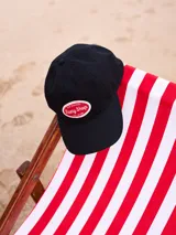 Gorra de lona lavada color azul con visera curva y parche bordado con el logo de Rusty en el frente.