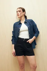 Short negro de gabardina, corte recto, con bolsillos delanteros y traseros, y presillas para cinturón.