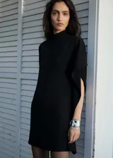 Vestido corto negro con diseño evasé y mangas asimétricas.