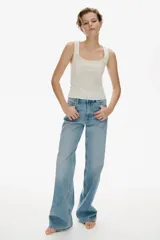 Musculosa blanca de punto pointelle suave, corte ajustado, con escote cuadrado, moño de satén y bajo sobrehilado.