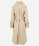 Trench coat largo color beige confeccionado en gabardina de algodón, con cuello solapa, cierre frontal abotonado, cinturón con hebilla, bolsillos laterales y trabillas en los puños.