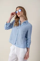 Camisa blanca de lino con cuello clásico, abotonada al frente y mangas 3/4 con puños.