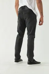 Pantalón de jean gris oscuro con roturas en las rodillas, corte recto y logo bordado.