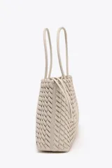 Bolso shopper alargado color beige con diseño trenzado, doble asa de hombro y cierre con botón imantado. Incluye bolsa interior con cierre fruncido.