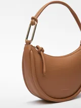 Bolso de hombro color marrón claro, con textura napa, un compartimento, cierre de cremallera, bolsillo interior con cierre de cremallera, asa tubular con pieza metálica y logo grabado.