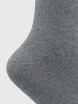 Calcetines grises de largo medio, tejido grueso y puño suave.