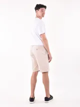 Bermuda color beige con bolsillos laterales y traseros.