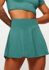 Pollera short deportiva color verde esmeralda, con short interno con bolsillos laterales.