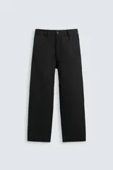 Pantalón de vestir color blanco hueso, de corte recto y tiro medio, con cintura elástica y cierre frontal de botón y cremallera. Presenta bolsillos frontales y bolsillos traseros de vivo.