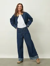 Jean de mezclilla azul oscuro, tiro alto, corte ancho y pierna recta muy amplia, con puños doblados que muestran el interior más claro.