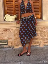 Pollera midi marrón con lunares celestes, de corte evasé y cintura alta.