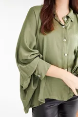 Camisa verde oliva de satén, con cuello clásico, cierre frontal con botones y mangas largas abullonadas con puños abotonados.