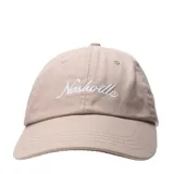 Gorro estilo dad hat color beige, con visera curva y bordado frontal en hilo blanco con la palabra "Nashville" en cursiva.