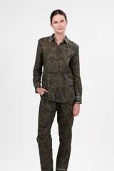 Camisa verde con estampado de soles y animales, de corte clásico, con cuello y puños blancos con detalle de líneas negras.