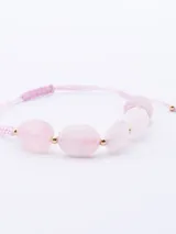 Pulsera elástica con cuentas de cuarzo rosado de diferentes tamaños y detalles dorados.
