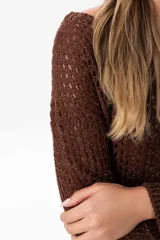 Sweater marrón de tejido calado con lurex en cuello, puños y ruedo. El escote puede usarse de dos formas: mostrando un hombro o de forma clásica.