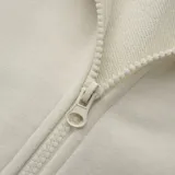 Campera con capucha color crema, con cierre frontal y bolsillos tipo canguro.