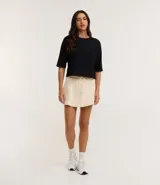 Short pollera color crema con cintura elástica y lazo ajustable.