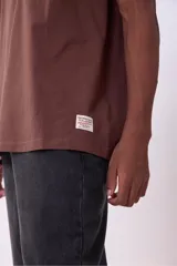 Remera color beige de corte recto y mangas cortas.