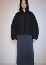 Chaqueta bomber negra oversize con cuello alto, cierre de cremallera frontal, mangas largas con puños elásticos, bajo con goma elástica y dos bolsillos laterales.