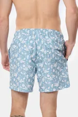 Short de baño celeste con estampado de flores blancas, cintura elástica con cordón ajustable, bolsillos laterales y suspensor de malla fina.