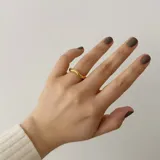 Anillo dorado de acero quirúrgico hipoalergénico con baño en oro 18K, de forma irregular.