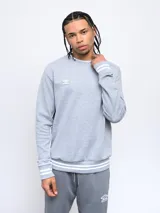 Buzo celeste de corte clásico con logo Umbro bordado en el pecho. Presenta cortes y cambio de color en las mangas, y ribete con rayas grises en cuello, puños y cintura.