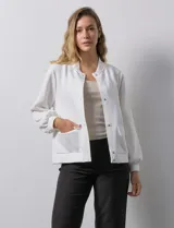 Campera bomber blanca con cuello a la base, abertura central con botones, bolsillos delanteros, ruedo y puños elastizados.