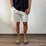 Bermuda negra de lino con corte arriba de la rodilla y cordón ajustable en la cintura.