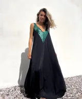 Vestido largo negro con escote en V y apliques de lentejuelas verdes en la parte superior.