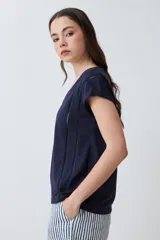 Remera color durazno con escote en V y detalle de vainillas en los laterales. De manga corta y corte recto.