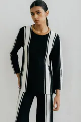 Sweater de punto color blanco con rayas verticales negras y cuello redondo color beige.