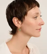 Set de tres pares de aros dorados: un par de aros tipo argolla con textura trenzada, un par de aros con colgantes de piedras verdes irregulares y un par de aros con tres piedras verdes cada uno.