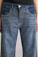 Pantalón de jean de tiro medio y corte wide leg, color azul, con apliques de strass plateados.