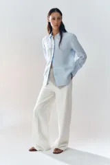 Camisa color ladrillo confeccionada en lino 100%, de corte recto, con cuello solapa, manga larga con puños y cierre frontal con botones.