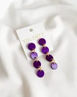 Aros colgantes con círculos de acrílico color violeta unidos por aros dorados.