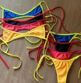 Traje de baño de dos piezas color amarillo, compuesto por un corpiño triangular con tirantes finos y una bombacha cavada con lazos laterales.