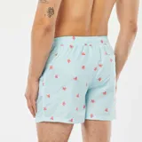 Short de baño celeste con rayas verticales blancas y estampado de pulpos rojos.