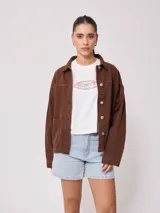 Campera marrón de algodón con cuello camisero, cierre con botones a presión, bolsillos frontales y corte holgado.