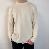 Sweater tejido color crema con cuello redondo y terminaciones con efecto desgastado y roturas.