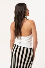 Top blanco de cuello volcado, confeccionado en tejido de punto suave y adaptable.