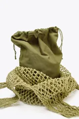 Bolso shopper de hombro color verde oliva, trenzado con cordones gruesos. Tiene doble asa ancha para el hombro y un bolso interior de tela con cierre fruncido.