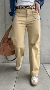 Pantalón de jean color beige, de corte recto y tiro alto, con bolsillos delanteros y traseros.