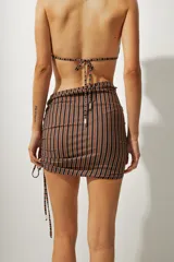 Minifalda de playa con estampado a rayas verticales azules y negras, con cordones laterales ajustables.