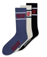 Pack de tres pares de medias deportivas de caña media/alta. Un par azul con franjas blancas y texto rojo, un par blanco hueso con franjas azul marino y texto rojo, y un par negro con franjas blancas y texto rojo.