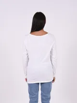 Remera blanca de manga larga con cuello redondo y estampado rectangular frontal con hojas de palmera en blanco y negro.